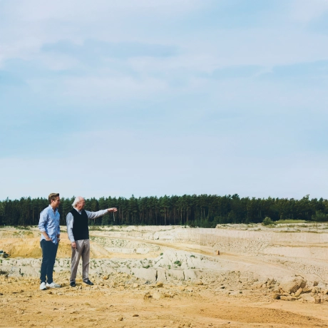 Max Godelmann und Bernhard Godelmann Senior stehen am Rand einer Klippe in der Sandgrube und blicken über die Grube.