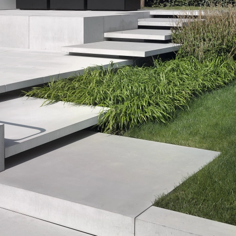 Garten mit großen Schwebestufen und großformatige Terrassenplatten aus Hochleistungsbeton in hellgrau.