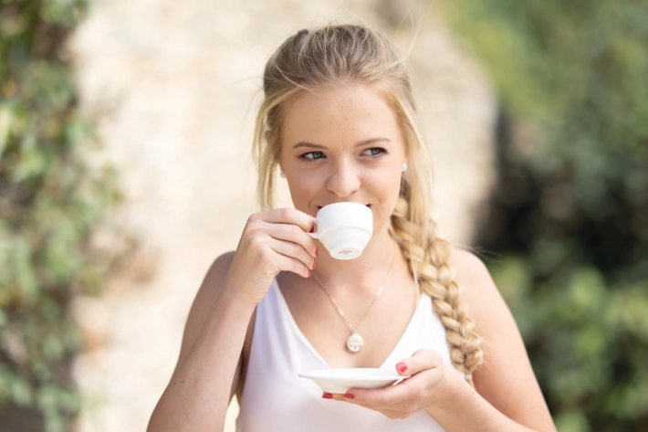 A woman drinks a coffee.