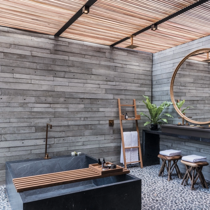  Betonfliesen GDM.APPARENTE tile an der Wand verbaut. Im Vordergrund ein Tisch