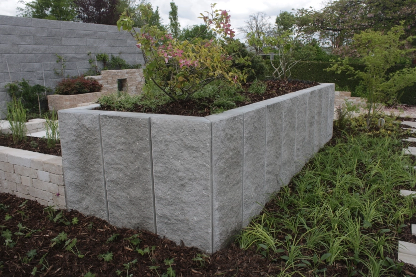 Hochbeet aus grauen Winkelstufen aus Beton in rustikaler Optik