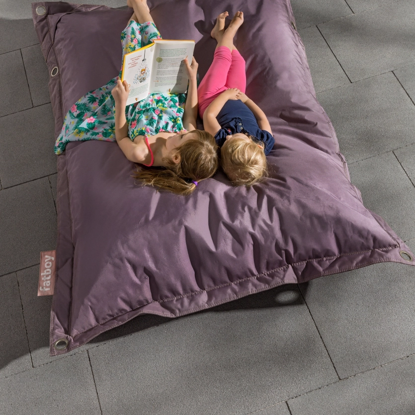 Two children lying on a fatboy.