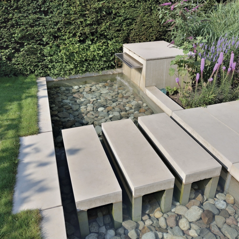 Wasserlauf mit Weg aus Pflastersteinen in beige 