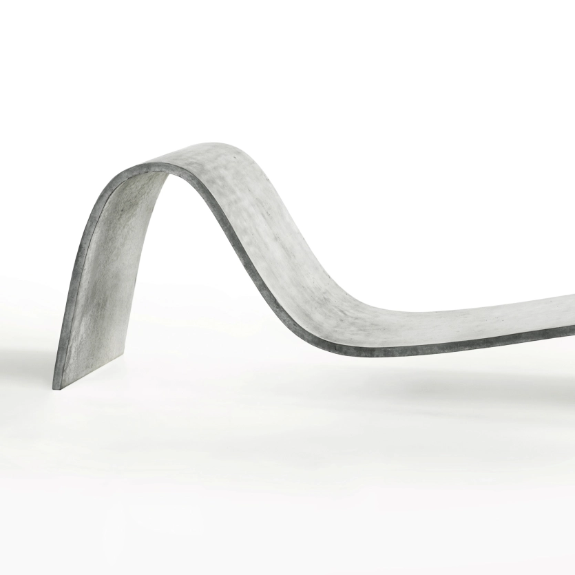 Edel geschwungene Betonliege Zephyr in klassischem Betongrau  vor weißem Hintergrund
