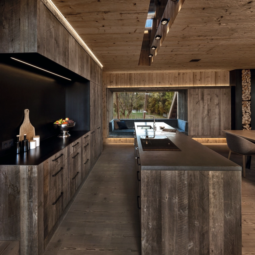 Küche mit Holzverkleidung und zwei Arbeitsplatten aus Beton