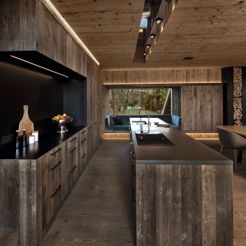 Kitchen with wood paneling and two concrete worktops