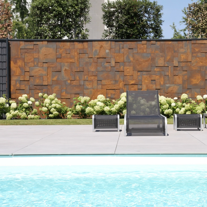 Sichtschutz hinter einem Pool in corten Optik als Beton - Architekturbeton 