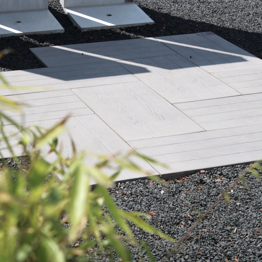 Helle Terrassenplatten mit Holzoptik verlegt auf einem fachgerechten Untergrund.