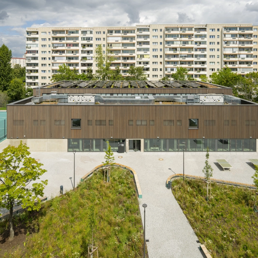 Luftbildaufnahme auf die Peter Pan Grundschule in Berlin. Im Hintergrund ist eine Hochhaussiedlung zu sehen.