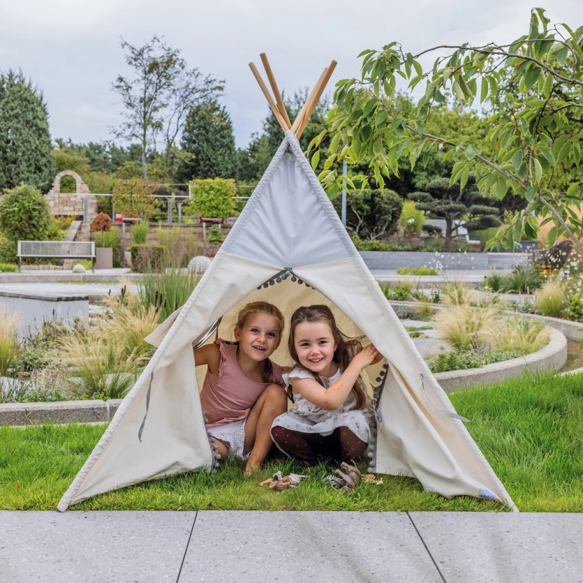 Zwei Mädchen schauen aus einem weißen Tipi