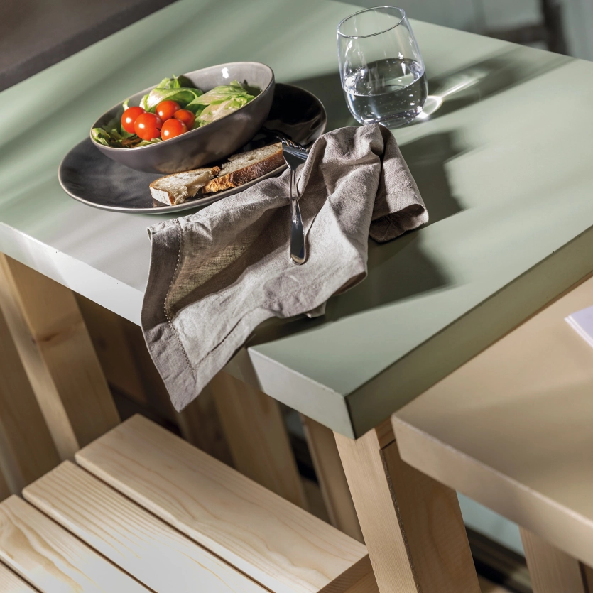 Tischplatte aus mintgrünem Beton mit einem Obstteller