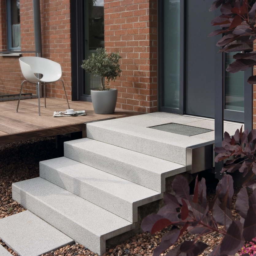Hauszugang mit einer filigranen Treppe aus Winkelstufen und Einganspodest aus Beton 