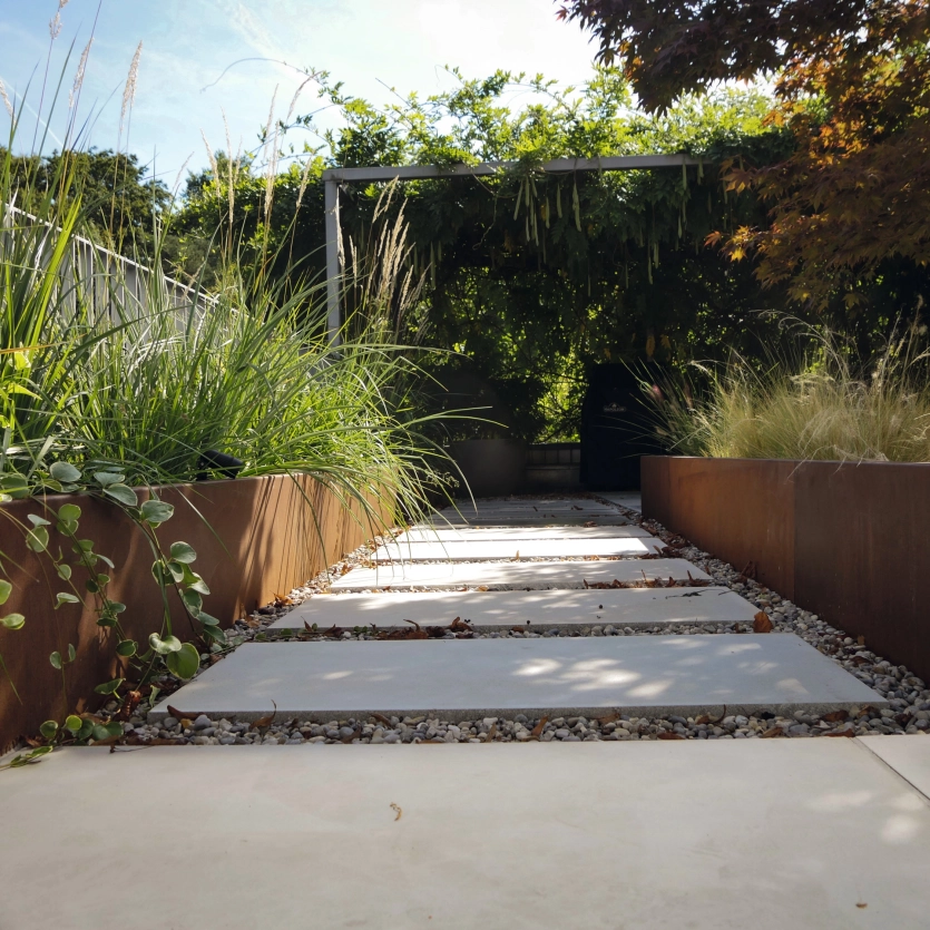 Dachterrasse mit Betonplatten Corten Hochbeete und viele Pflanzen 