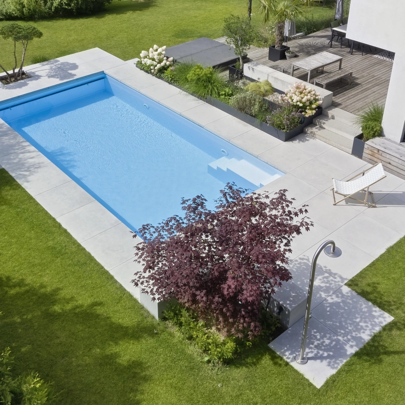 Pool in einem minimalistischen Garten mit XXL-Terrasenplatten als Umrandung