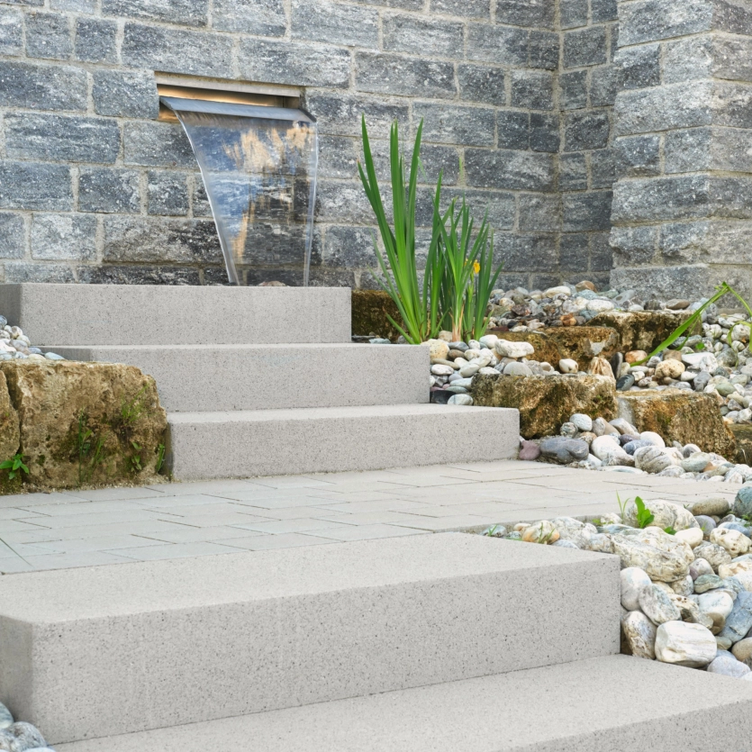 Limestone-colored steps to a watercourse from the wall.