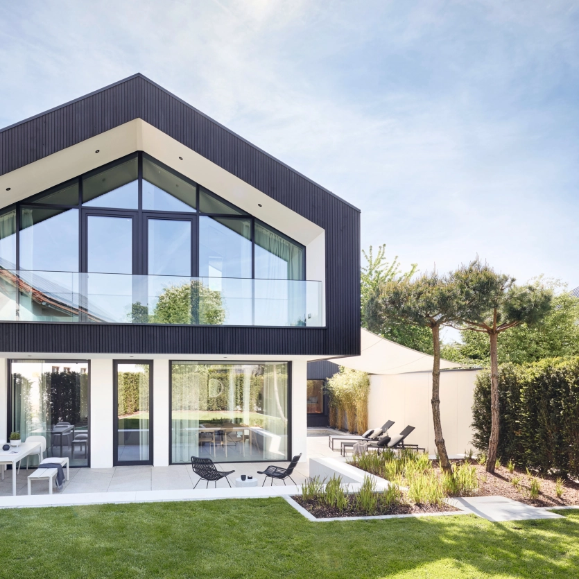 Modern house with glass façade and concrete patio slabs.