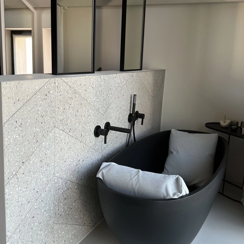 Bathroom with black bath and herringbone wall tiles