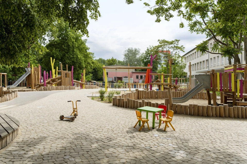 Außenbereich der Kita Wolkenschaf in Berlin mit Spielbereichen, Rutschen und Aufenthaltsflächen auf versickerungsfähigem GDM.BOLERO.