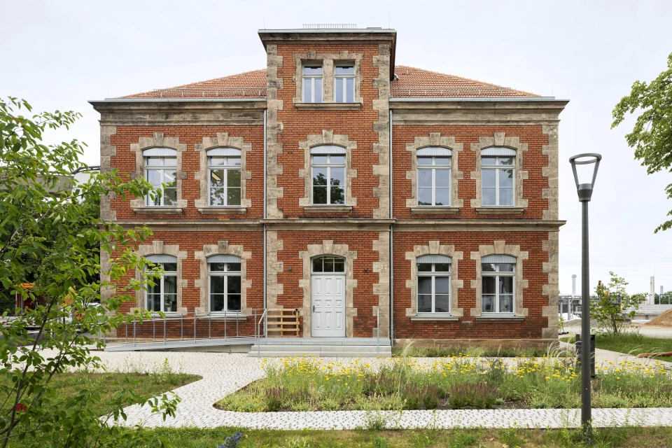 Historisches Gebäude der RekoSUN Stadtentwässerung Nürnberg mit Wegen GDM.ACENTRO stone in Granit Perlmut-Gelb im Vordergrund.