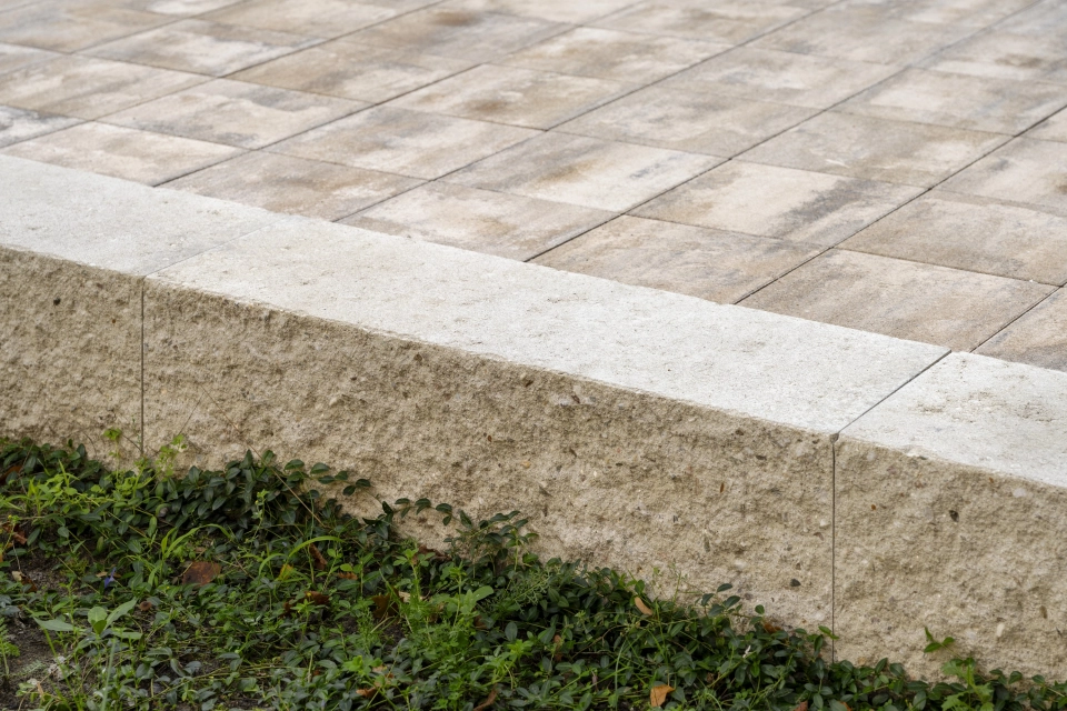 Betonblock GDM.MAXI block als Randbegrenzung des Weges. Dieser ist mit muschelkalkfarbenem Betonstein gepflastert.
