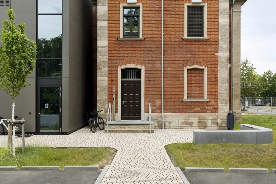 Eingangsbereich der RekoSUN Stadtentwässerung Nürnberg mit GDM.ACENTRO stone in Granit Perlmut-Gelb.