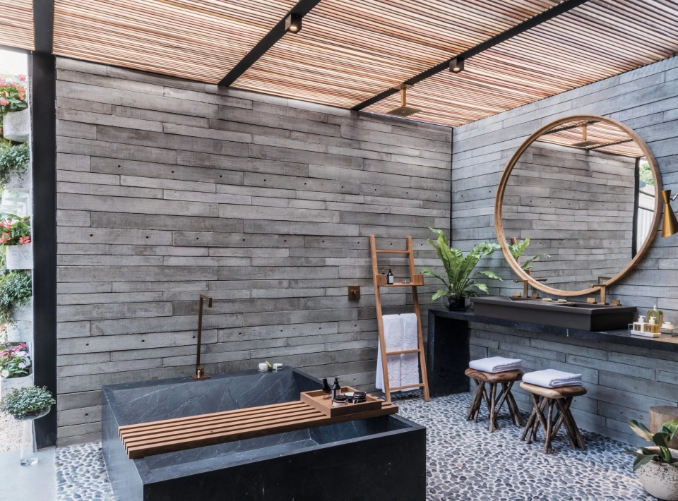  Betonfliesen GDM.APPARENTE tile an der Wand verbaut. Im Vordergrund ein Tisch